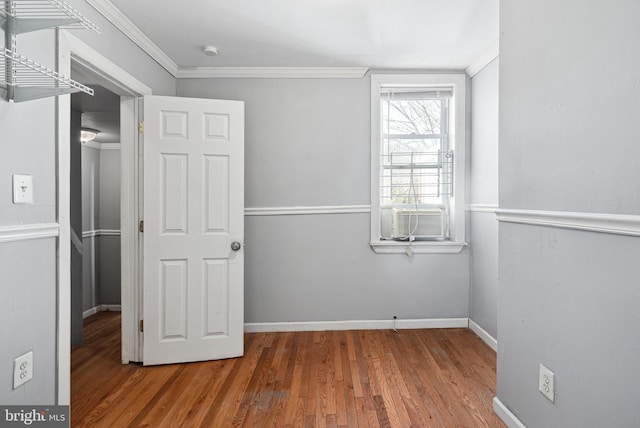 unfurnished bedroom with cooling unit, ornamental molding, and hardwood / wood-style flooring