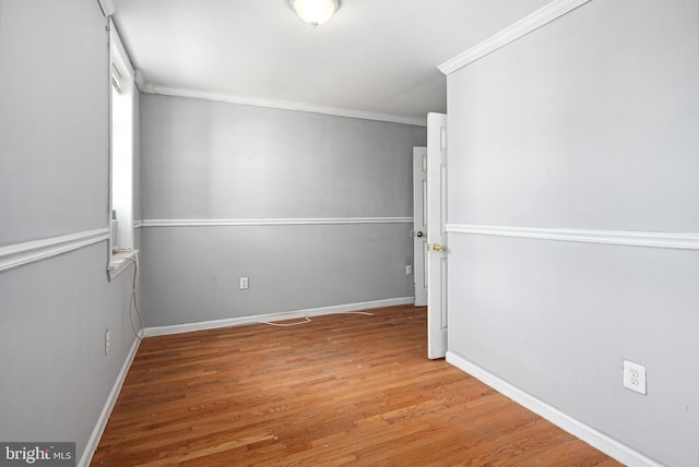 spare room featuring crown molding and wood-type flooring