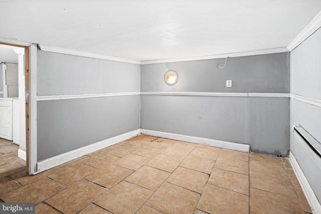 tiled empty room featuring crown molding and washer / dryer