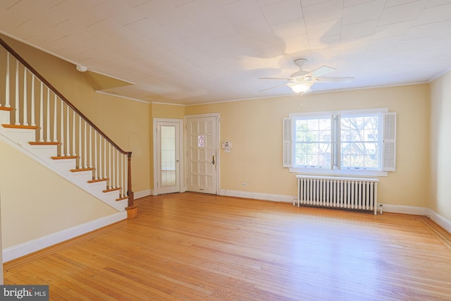 foyer entrance with ceiling fan, radiator, and light hardwood / wood-style floors