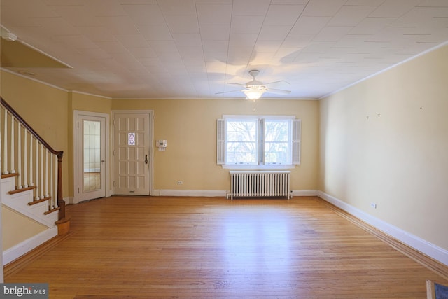 entryway with ceiling fan, ornamental molding, radiator heating unit, and light hardwood / wood-style floors