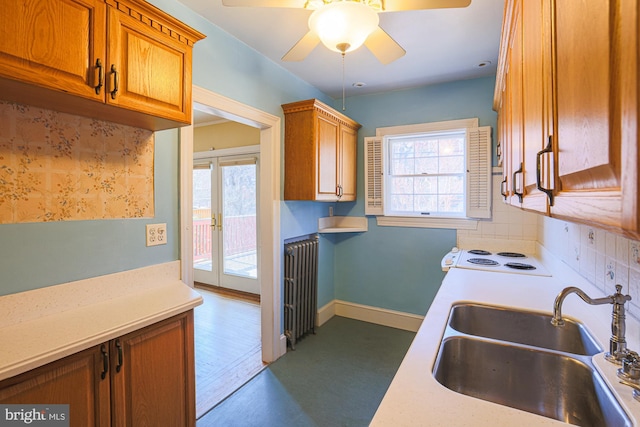 kitchen with radiator, sink, decorative backsplash, ceiling fan, and french doors