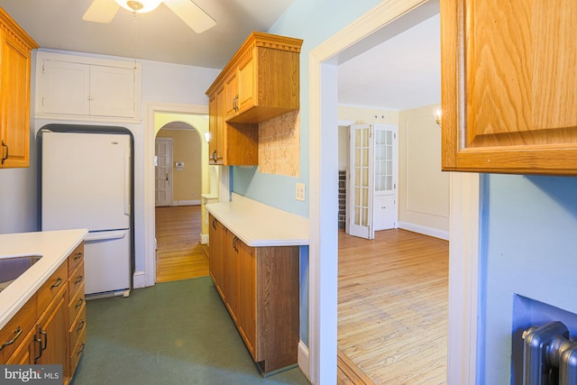 kitchen featuring white fridge, dark hardwood / wood-style floors, radiator heating unit, and ceiling fan