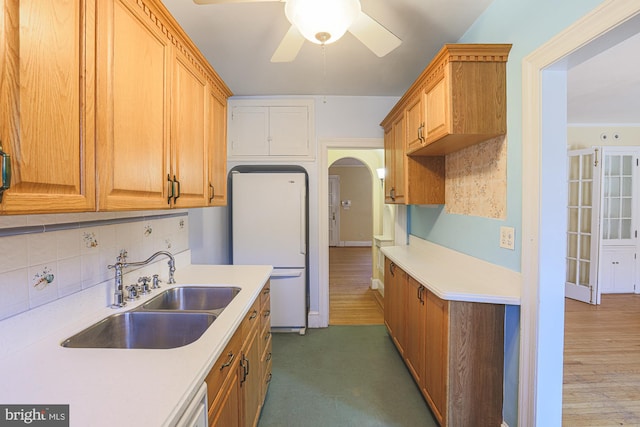 kitchen with sink, dark wood-type flooring, ceiling fan, backsplash, and white refrigerator