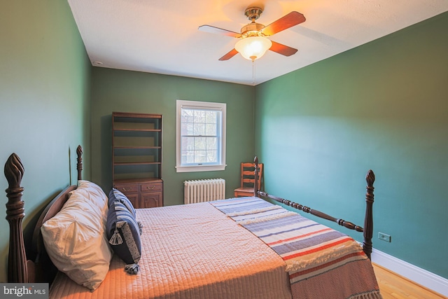 bedroom with radiator, light hardwood / wood-style flooring, and ceiling fan