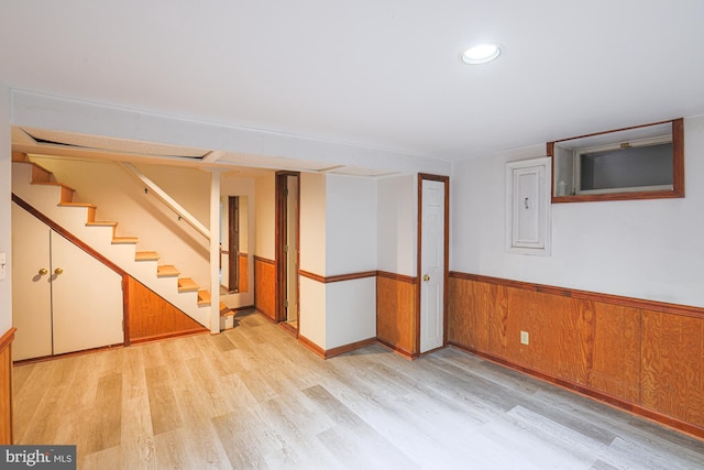 basement featuring light hardwood / wood-style floors and electric panel