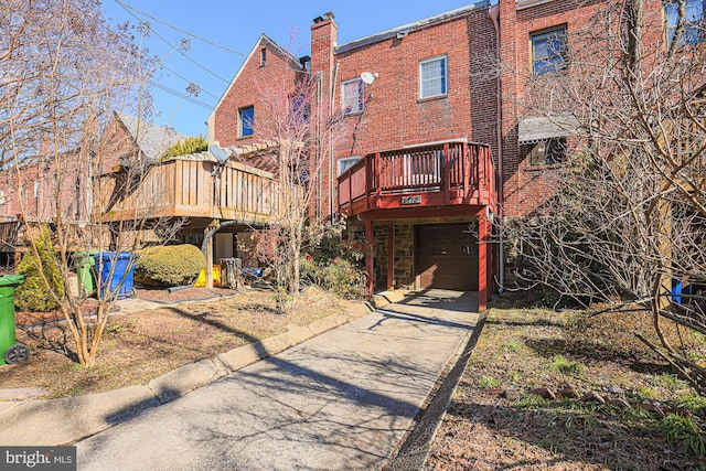 back of property featuring a garage and a wooden deck