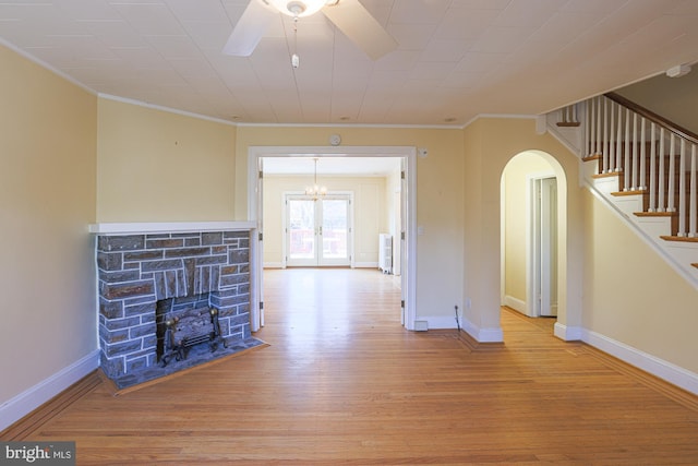 unfurnished living room with crown molding, ceiling fan, light hardwood / wood-style floors, and french doors