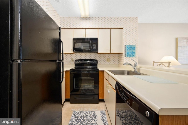 kitchen with light tile patterned flooring, sink, a textured ceiling, and black appliances