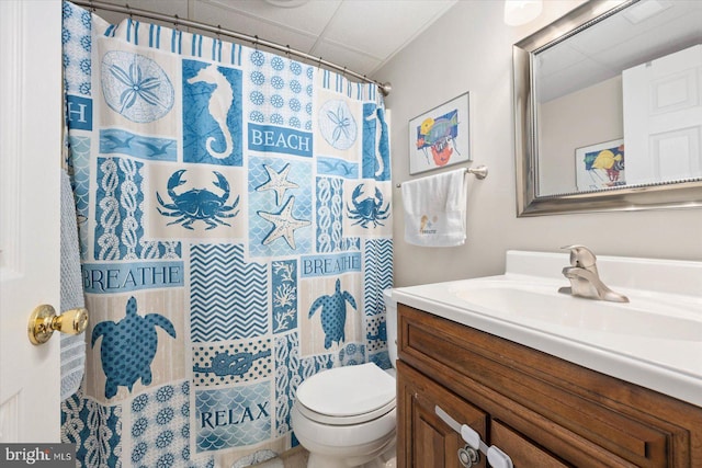 bathroom with walk in shower, vanity, and toilet