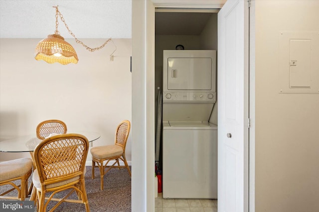 laundry room featuring stacked washer / dryer and electric panel