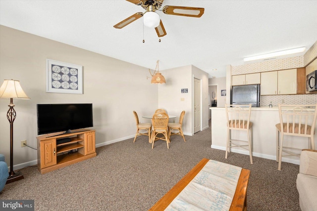 carpeted living room with a textured ceiling and ceiling fan