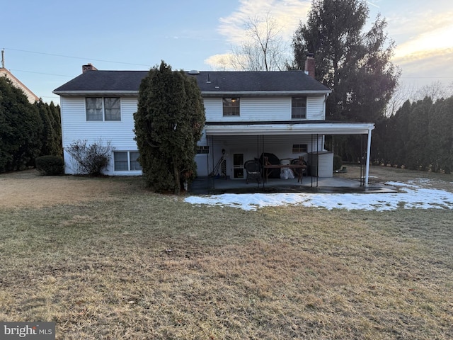 back of house featuring a patio area and a lawn