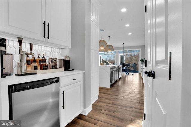 bar featuring dishwashing machine, hanging light fixtures, tasteful backsplash, white cabinets, and dark hardwood / wood-style flooring