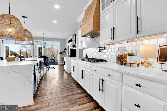 kitchen featuring stainless steel gas cooktop, decorative light fixtures, sink, and white cabinets