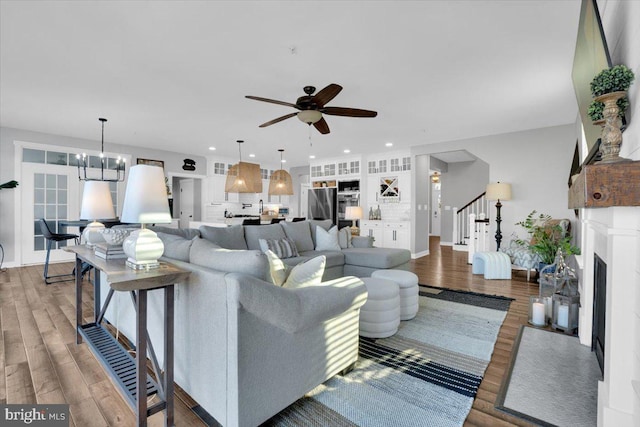 living room featuring hardwood / wood-style flooring and ceiling fan with notable chandelier