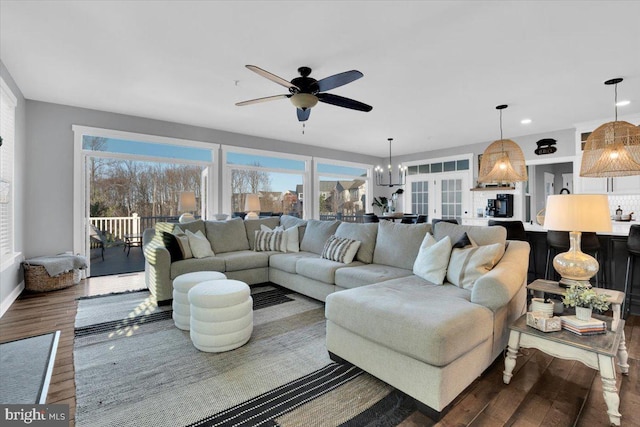 living room featuring dark hardwood / wood-style floors and ceiling fan with notable chandelier