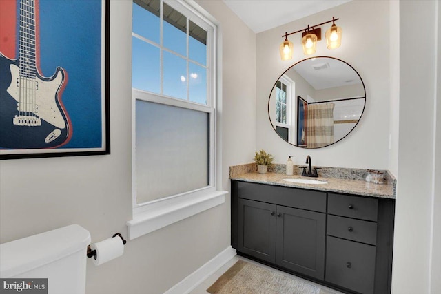 bathroom featuring vanity, a shower with shower curtain, and toilet