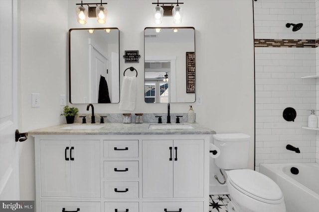 full bathroom with vanity, tiled shower / bath, and toilet