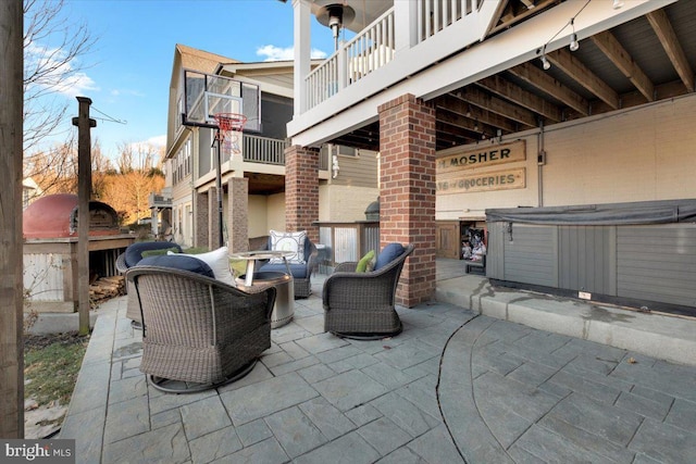 view of patio featuring a balcony, a hot tub, and an outdoor hangout area