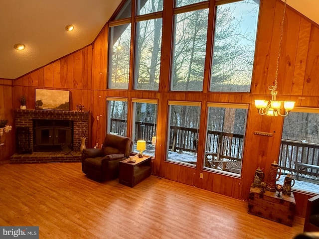 living room featuring a fireplace, light hardwood / wood-style flooring, and wood walls