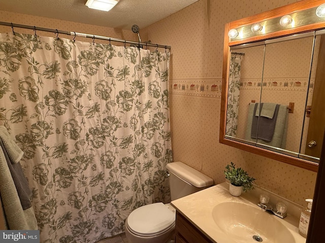 bathroom with walk in shower, vanity, toilet, and a textured ceiling