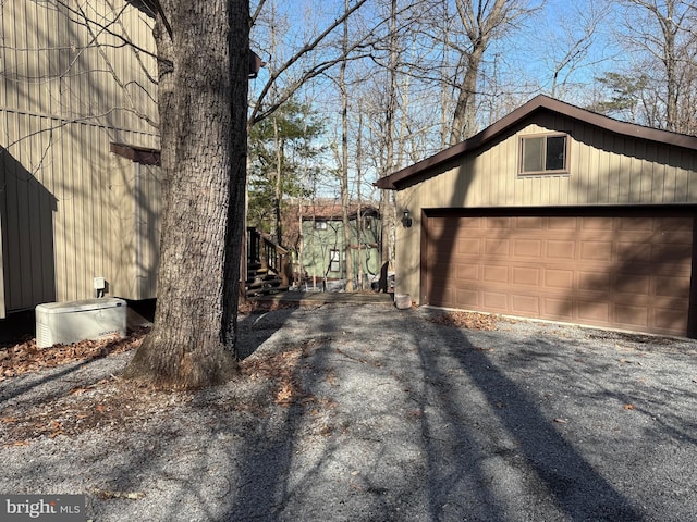 view of home's exterior with a garage and an outbuilding