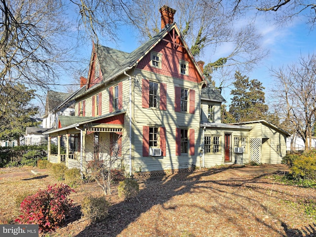 view of home's exterior with a chimney and cooling unit