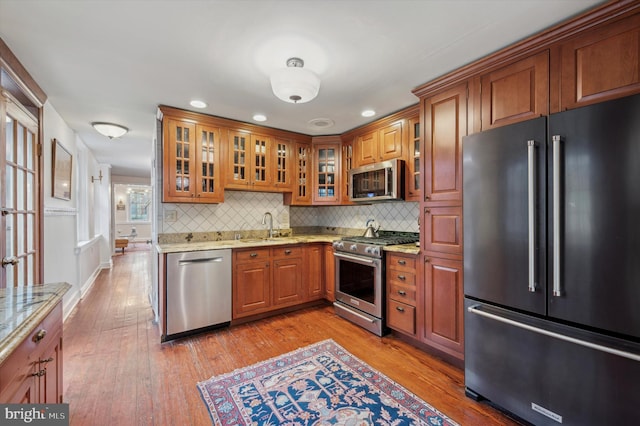 kitchen with light stone countertops, sink, and premium appliances