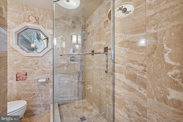 bathroom featuring toilet and a tile shower