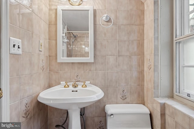 bathroom with tile walls and toilet