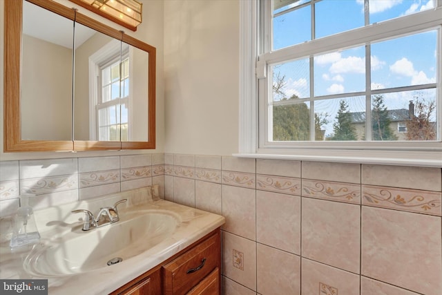 bathroom featuring vanity and tile walls