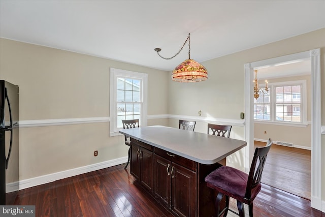 dining area featuring a healthy amount of sunlight and dark wood-type flooring