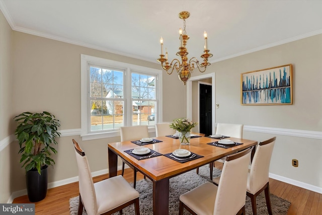 dining room with crown molding, hardwood / wood-style floors, and a notable chandelier