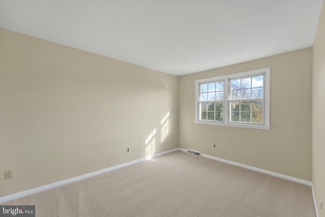 spare room featuring light carpet