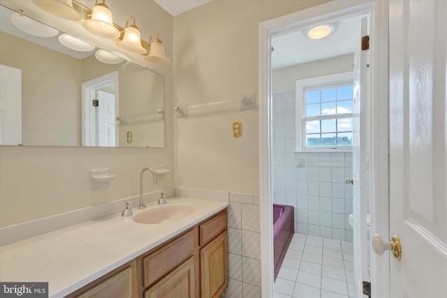 bathroom with tile walls, vanity, and tile patterned flooring