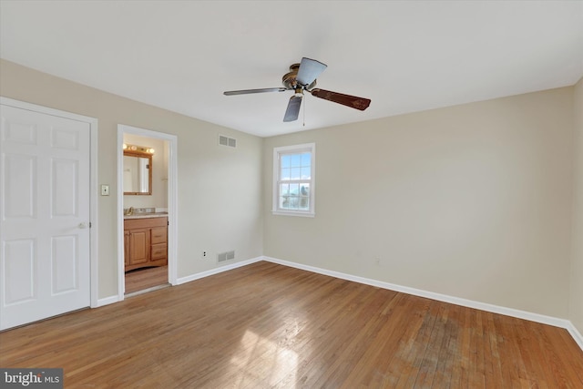 unfurnished bedroom featuring connected bathroom, ceiling fan, and light wood-type flooring