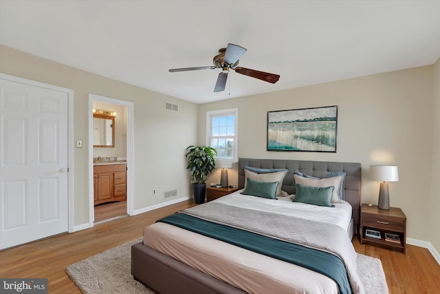 bedroom with ceiling fan, ensuite bath, and light hardwood / wood-style floors