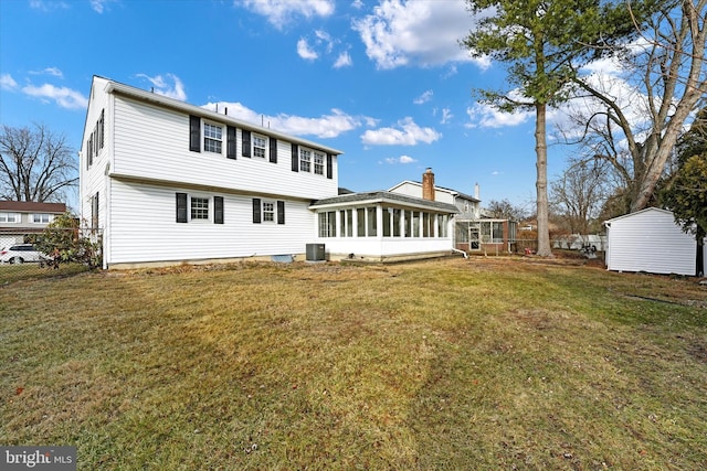 back of property with a sunroom, central AC, and a lawn