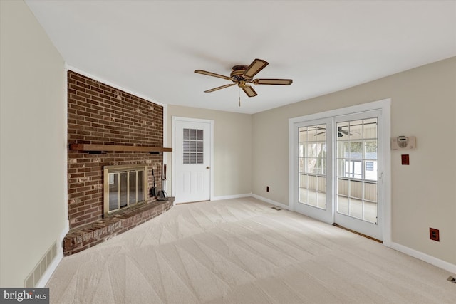 unfurnished living room featuring light carpet, a brick fireplace, and ceiling fan