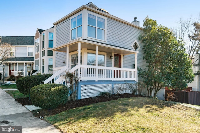 front facade with covered porch and a front lawn