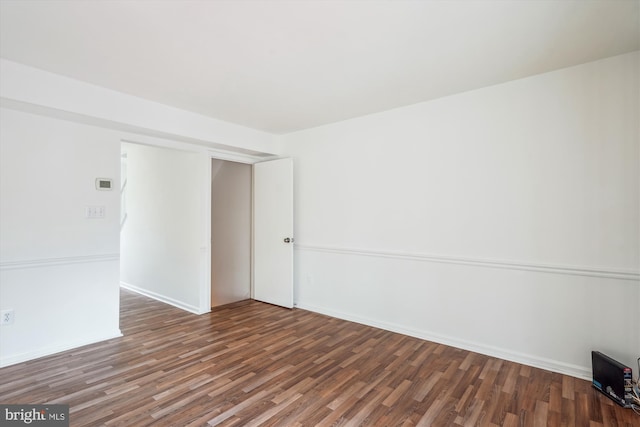 unfurnished room with baseboards and wood finished floors