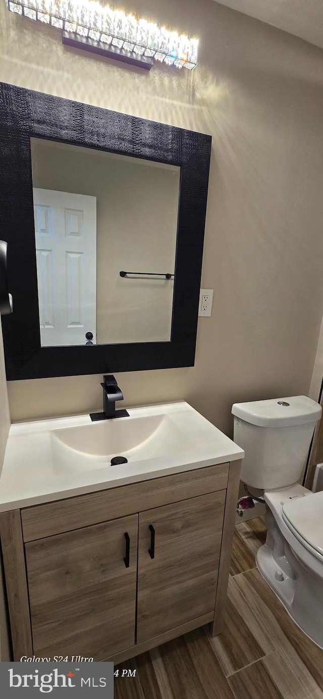 bathroom featuring vanity, toilet, and hardwood / wood-style floors