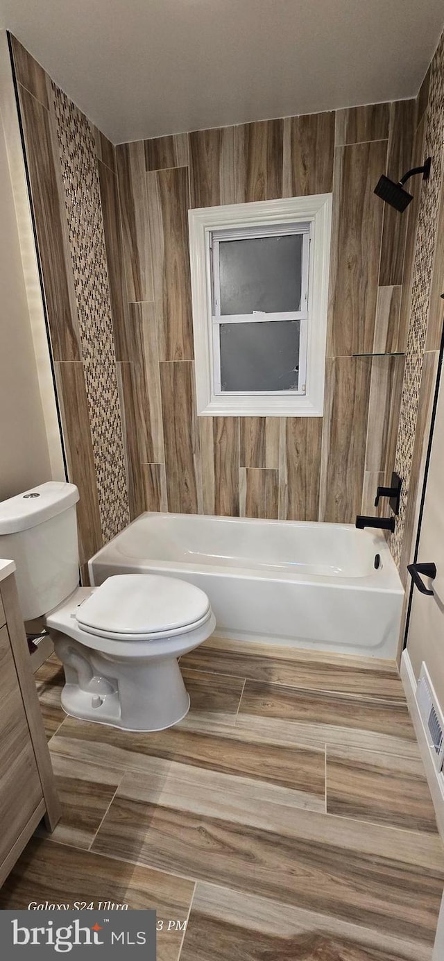 bathroom with tiled shower / bath and toilet