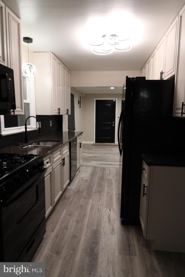 kitchen with white cabinetry, pendant lighting, hardwood / wood-style floors, and black appliances