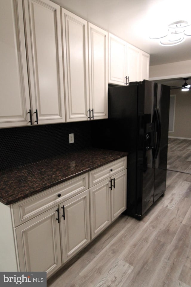 kitchen featuring white cabinets and black fridge with ice dispenser