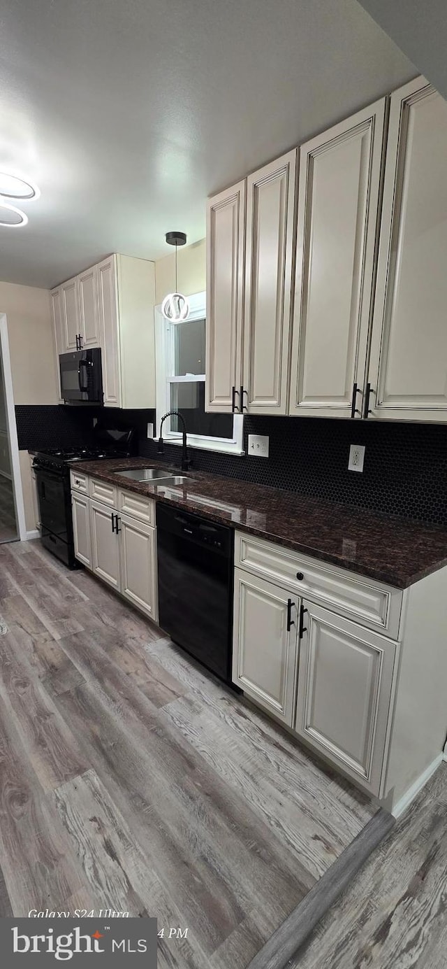 kitchen with white cabinetry, decorative light fixtures, sink, and black appliances