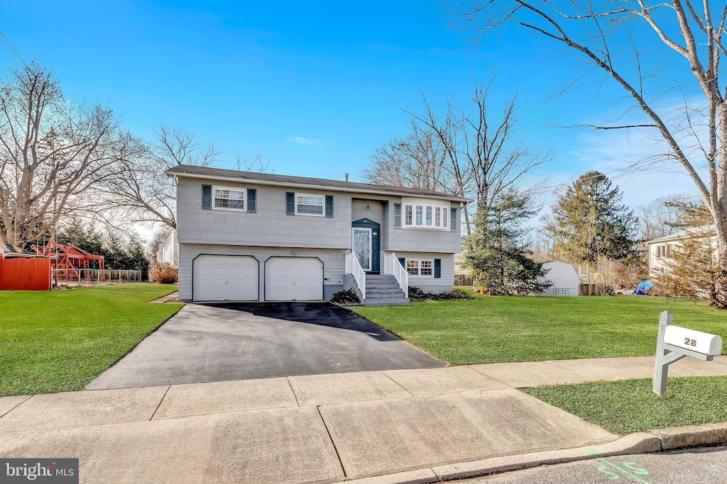 raised ranch featuring a garage and a front yard