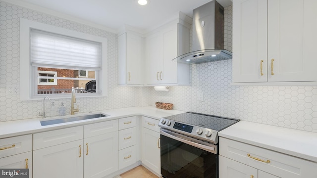 kitchen featuring sink, white cabinets, backsplash, wall chimney range hood, and electric stove