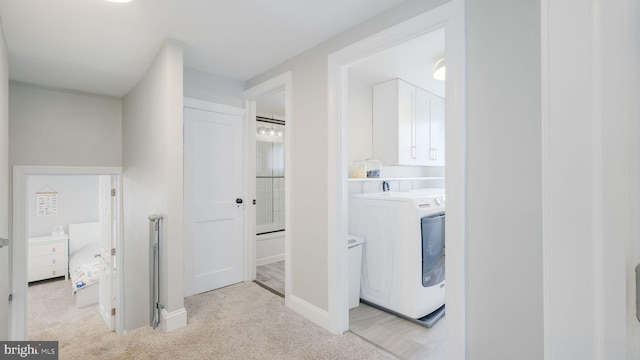 washroom featuring cabinets, washer / clothes dryer, and light colored carpet